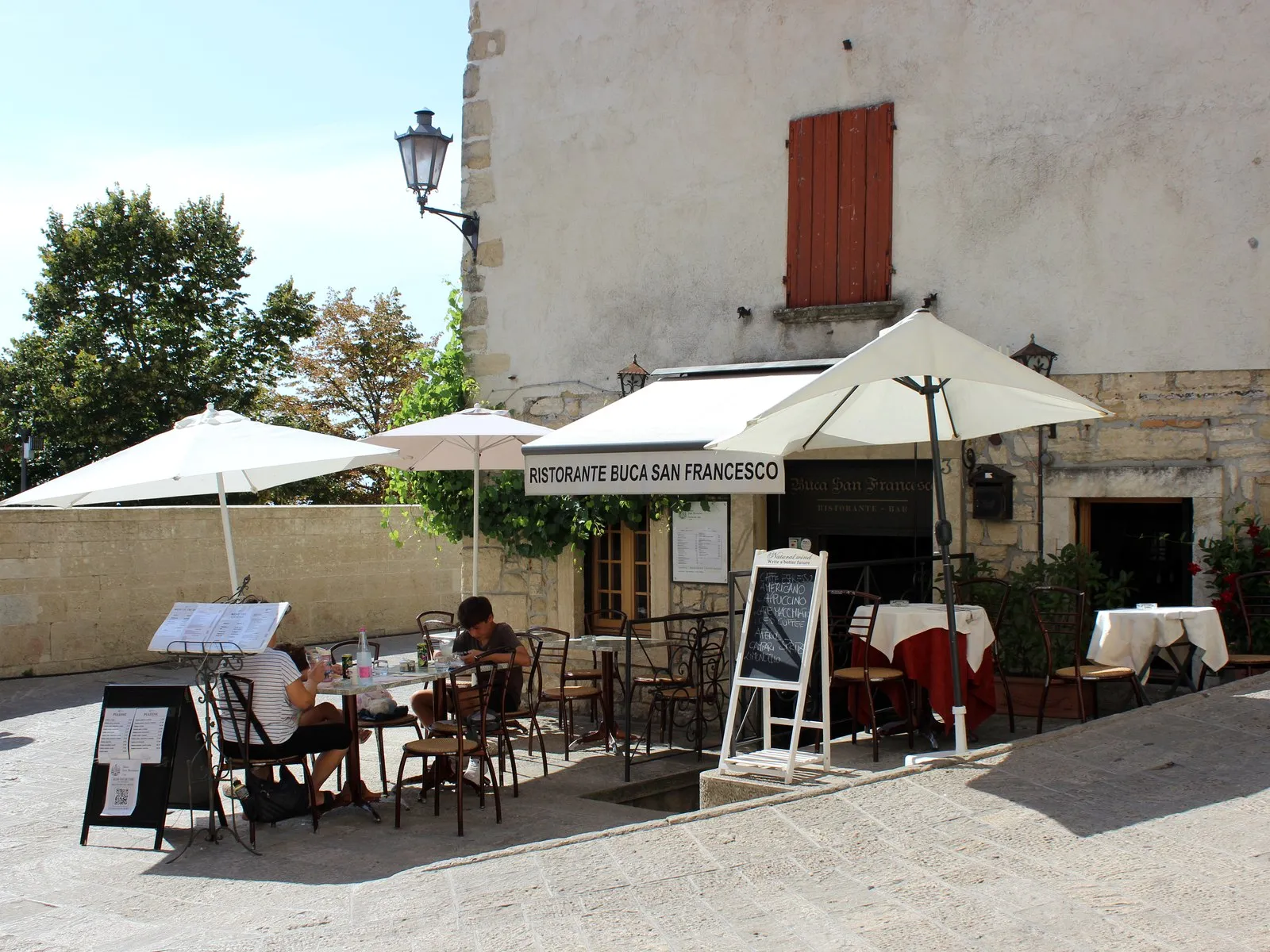 Restauranteingang und Tische im Freien nahe der Porta San Francesco